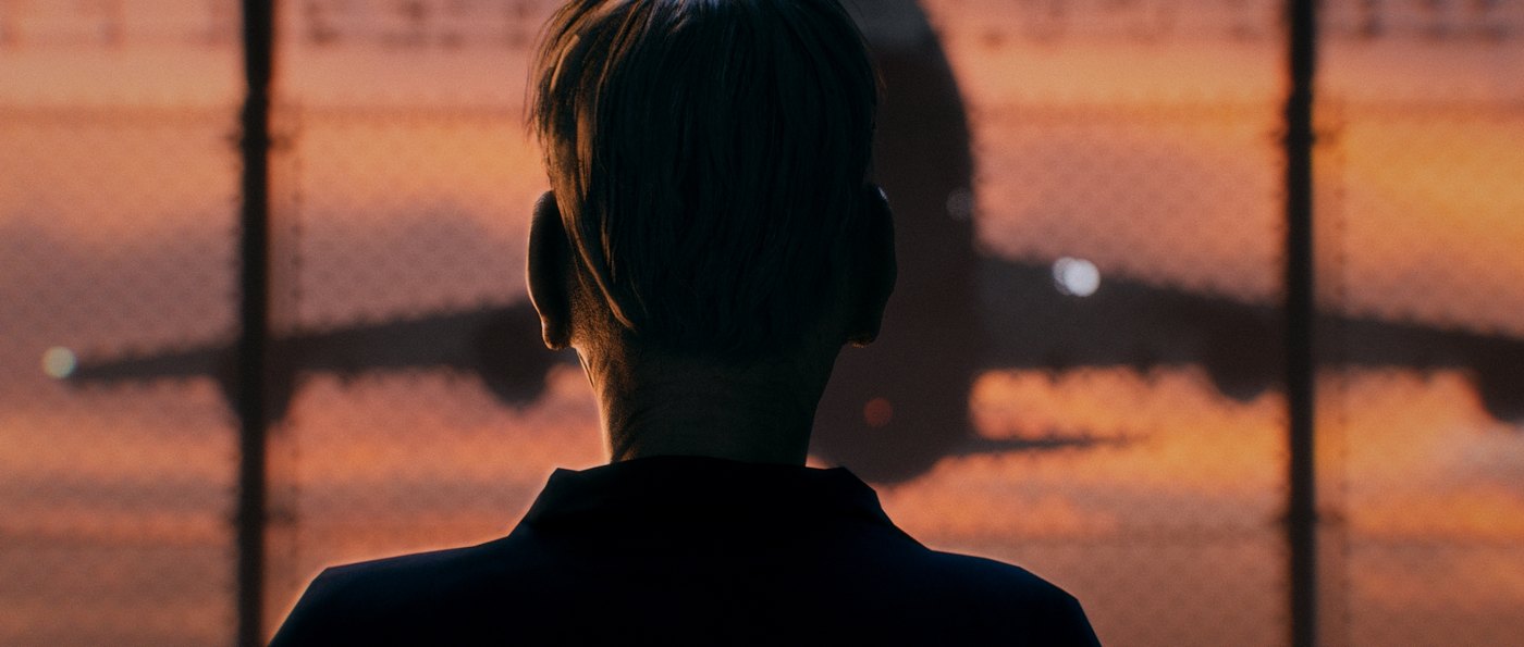 Forest Bathing — still: figure silhouetted against an airport window at dusk